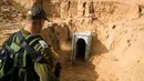 Seorang tentara Israel berdiri di depan terowongan yang menghubungkan Palestina dengan Israel di dekat Kibbutz selatan Kissufim, Israel, Kamis (18/1). Tentara Israel menyatakan sebagian terowongan yang ditemukan telah hancur. (Jack Guez/Pool via AP)
