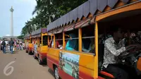 Pengelola Monas menyediakan mobil gandeng untuk berkeliling di kawasan Monas, Jakarta, Sabtu (26/12/2015). Akses yang mudah dan harga yang murah menjadi alasan warga menjadikan Monas tujuan wisata mereka. (Liputan6.com/Yoppy Renato)
