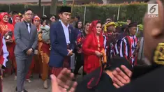Presiden Joko Widodo dan Ibu Negara Iriana berjalan saat mengikuti  prosesi penyambutan keluarga mempelai wanita secara adat di Bukit Hijau Regency Taman Setia Budi (BHR Tasbi), Medan, Sabtu (25/11). (Liputan6.com/Vidio)