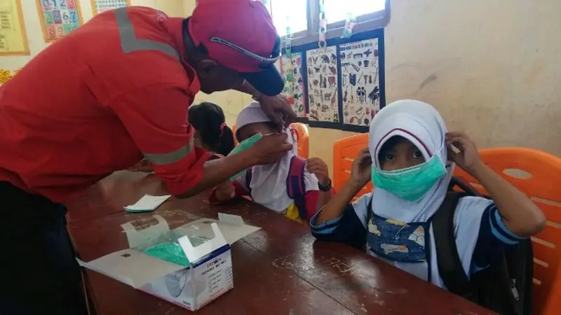 Murid SDN 29 Rupat dipasangi masker sebagai antisipasi jika kabut asap muncul lagi karena titik api masih ada