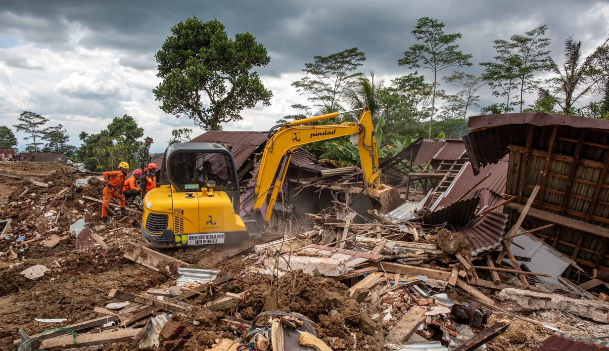 Alat berat dikerahkan untuk membuka tumpukan material, sementara anjing pelacak Unit K9 digunakan untuk menelusuri lokasi yang diduga menjadi titik tertimbun korban. Tampak dalam foto, tim penyelamat dan alat berat mencari korban yang tertimbun di bawah puing-puing rumah yang hancur di lokasi longsor di Desa Situkung, Banjarnegara, Jawa Tengah, pada Rabu 19 November 2025. (DEVI RAHMAN/AFP)