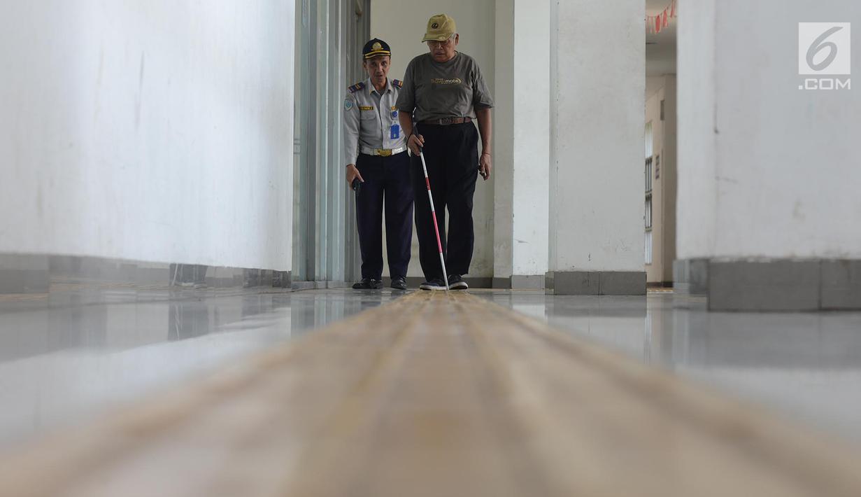 Penyandang disabilitas netra menyusuri ubin pemandu seusai mengikuti kampanye kegunaan ubin pemandu di Terminal Rawamangun, Jakarta, Selasa (2/4/2019). Kegiatan itu untuk memberikan pemahaman kepada masyarakat luas agar tidak terjadi penyalahgunaan di area ubin pemandu. (merdeka.com/Imam Buhori)