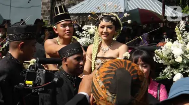 Pasangan pengantin Kaesang Pangarep dan Erina Gudono menaiki kereta saat prosesi kirab Ngunduh Mantu di kawasan Selamet Riyadi, Solo, Jawa Tengah, Minggu (11/12/2022). Kirab ngunduh mantu pernikahan putra bungsu Presiden Joko Widodo, Kaesang Pangarep dan istrinya Erina Gudono yang dimulai dari Loji Gandrung menuju Pura Mangkunegaran tersebut disaksikan ribuan masyarakat Solo dan sekitarnya. (Liputan6.com/Herman Zakharia)