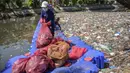 Mereka menemukan plastik sekali pakai, styrofoam, kemasan makanan, hingga limbah rumah tangga dari kawasan permukiman padat. Tampak dalam foto, aktivis dari Ecoton (Ecological Observation and Wetlands Conservation) bersama pekerja dari Dinas Lingkungan Hidup Pemerintah Kota Surabaya, Jawa Timur, membersihkan sampah dari Sungai Kali Tebu, pada Senin 11 Mei 2026. (JUNI KRISWANTO/AFP)