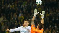 Kiper Borussia Dortmund, Roman Buerki menangkap bola yang ditendang pemain Real Madrid, Cristiano Ronaldo dalam lanjutan Liga Champions di Signal Iduna Park, Rabu (27/9). Dua gol Ronaldo mewarnai kemenangan Real Madrid 3-1. (AP/Michael Probst)