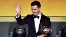 Pemain Barcelona, Lionel Messi melambaikan tangan sambil memegang trofi setelah memenangkan pemain terbaik dunia FIFA Ballon d'Or 2015 di Kongresshaus, Zurich, Senin ( 11/1). Ini adalah kelima kalinya Messi meraih Ballon d'Or. (AFP PHOTO/FABRICE COFFRINI)