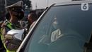 Polisi menghentikan mobil saat pemberlakuan ganjil genap di kawasan Fatmawati, Jakarta, Senin (25/10/2021). Pemberlakuan ganjil genap di DKI Jakarta diperluas menjadi 13 titik. (Liputan6.com/Herman Zakharia)