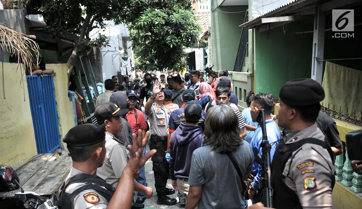 Kerumunan warga menyaksikan polisi menggeledah kediaman orang tua terduga teroris di Jalan Belibis V, Semper Barat, Cilincing, Jakarta, Senin (23/9/2019). Selain rumah tersangka, polisi juga menggeledah kediaman orang tua terduga teroris yang tidak jauh dari TKP. (merdeka.com/Iqbal S. Nugroho)