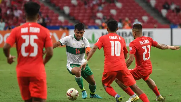 Pemain Indonesia Asnawi Mangkualam Bahar (kedua kiri) menggiring bola melewati para pemain Singapura pada pertandingan leg pertama semifinal Piala AFF 2020 di National Stadium, Singapura, Rabu (22/12/2021). Pertandingan berakhir imbang 1-1. (Roslan RAHMAN/AFP)