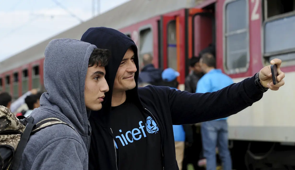 Duta UNICEF, Aktor Orlando Bloom (kanan) berselfie dengan Tariq Maria dari Damaskus, Suriah saat ia mengunjungi kamp transit migran di Gevgelija, Makedonia, 29 September 2015. (REUTERS/Ognen Teofilovski)