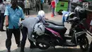 Petugas Dishub DKI menggembosi ban motor yang nekat parkir liar di trotoar sepanjang Jalan Kramat Raya, Senen, Jakarta, Jumat (22/9). Razia dilakukan untuk mengantisipasi arus lalu lintas yang kerap macet di kawasan itu. (Liputan6.com/Faizal Fanani)
