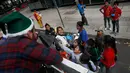 Juan Carlos Ascencio membagikan pakaian dan mainan sebagai hadiah Natal kepada anak-anak tidak mampu di jalanan Mexico City, Meksiko (23/12). (AP Photo / Marco Ugarte)