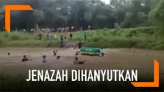 Sejumlah warga nekat menghanyutkan keranda berisi jenazah ke sungai yang arusnya deras.
