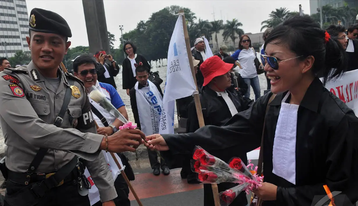 Aksi simpatik Peradi saat berunjuk rasa dengan membagikan bunga pada petugas kepolisian yang menjaga jalannya aksi, Jakarta, Kamis (11/9/2014) (Liputan6.com/Johan Tallo)