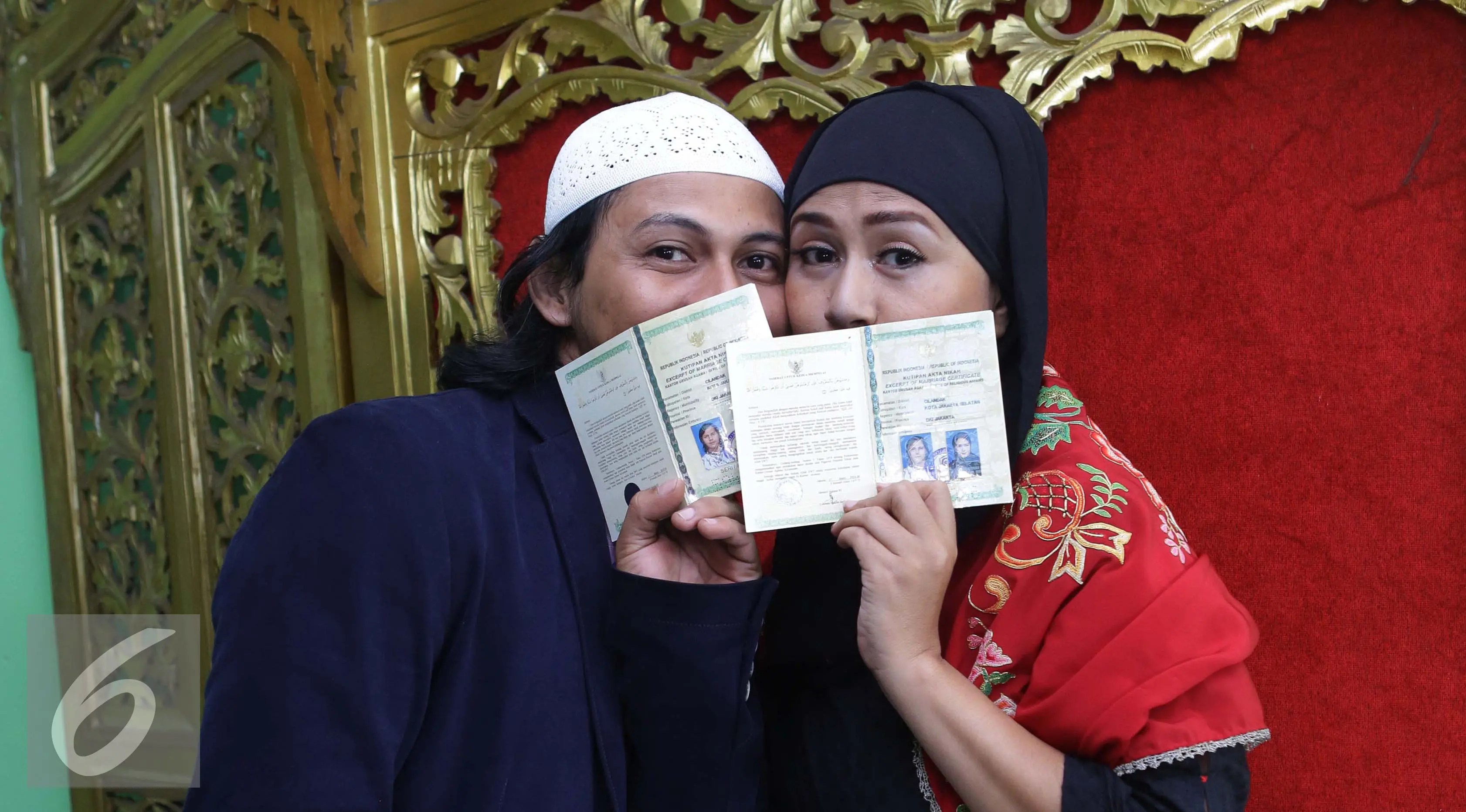 Ria Irawan bersama suaminya, Mayky Wongkar berpose menunjukan buku nikah usai Ijab Qabul di KUA Cilandak, Jakarta, Jumat (23/12). Akhirnya setelah 17 tahun menjanda, Ria menikah untuk kedua kalinya dengan asistennya sendiri. (/Herman Zakharia)