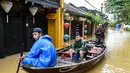 Orang-orang menyusuri jalan yang terendam banjir dengan perahu setelah hujan deras di Hoi An, Vietnam, Kamis 30 Oktober 2025. Badan Penanggulangan Bencana Nasional Vietnam mengatakan ada lebih dari 103.000 rumah terendam banjir, terutama di kawasan wisata utama Hue dan Hoi An. (NHAC NGUYEN/AFP)