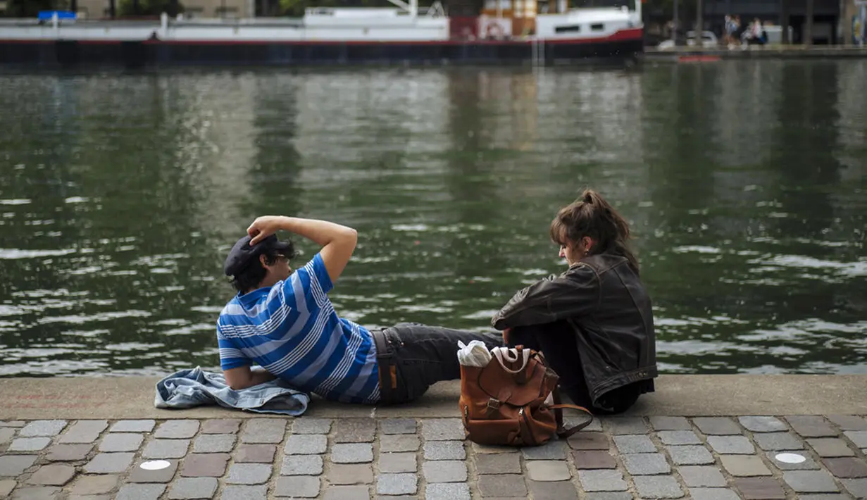 Orang-orang berjemur di Bassin de la Villette Canal, Paris, Prancis, Sabtu (5/6/2021). Jumlah kasus baru COVID-19 di Prancis semakin menurun. (AP Photo/Lewis Joly)