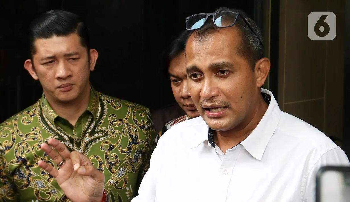 Wakil Menteri Hukum dan HAM (Wamenkumham) Edward Omar Sharif Hiariej (tengah) menjawab pertanyaan wartawan usai memberikan klarifikasi di Gedung Merah Putih KPK, Jakarta, Senin (23/3/2023). (Liputan6.com/Herman Zakharia)