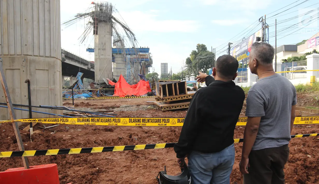 Dua orang warga melihat kondisi tiang girder Tol Bekasi-Cawang-Kampung Melayu (Becakayu) yang ambruk di Kebon Nanas, Jakarta Timur, Selasa (20/2). Tak ada penutupan jalur akibat robohnya tiang pancang tol Becakayu. (Liputan6.com/Arya Manggala)