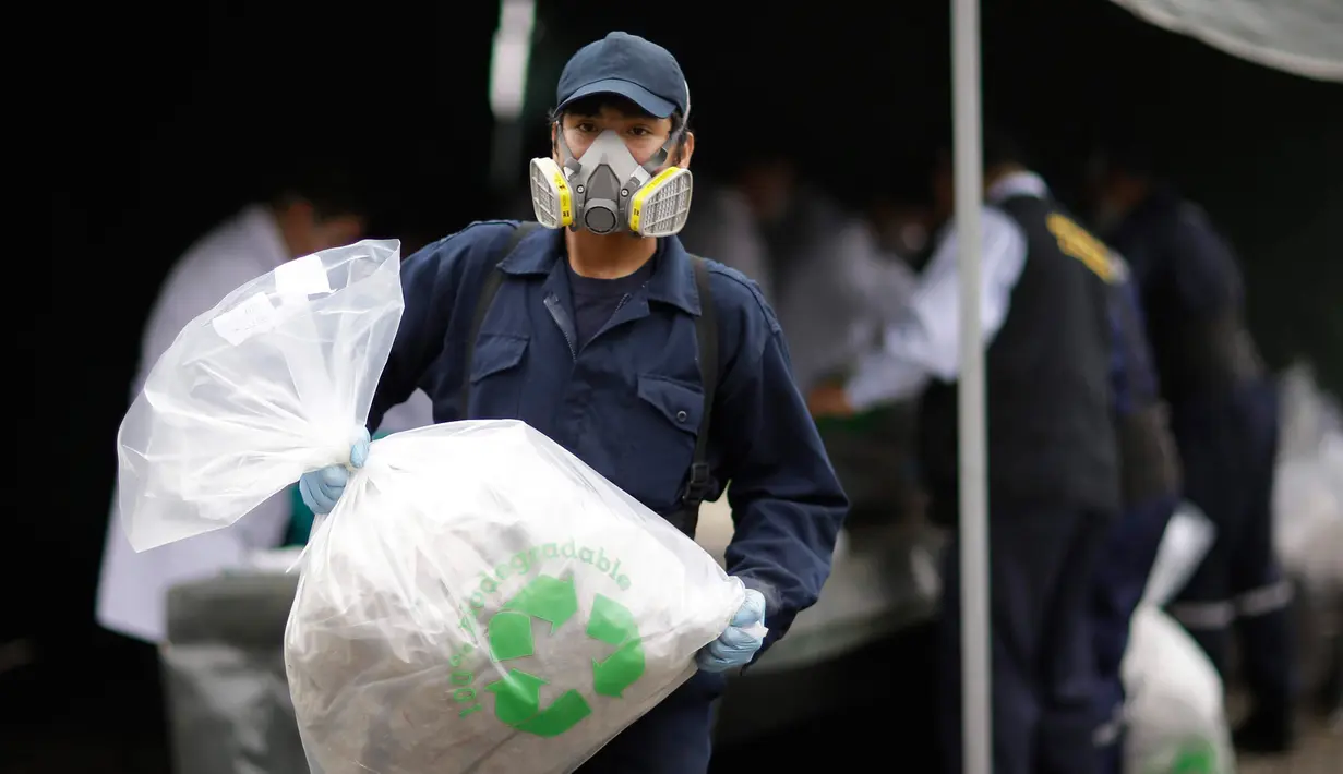 Pekerja memindahkan kokain yang siap dimusnahkan di markas polisi di Lima, Peru, (7/6). Polisi mengatakan mereka akan membakar sekitar 20 ton narkoba, termasuk kokain, mariyuana, opium dan heroin yang telah disita. (AP Photo/Martin Mejia)