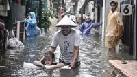 Aktivitas warga saat banjir merendam permukiman di Bukit Duri, Jakarta, Kamis (18/2/2021). Hujan deras yang mengguyur sejak pagi menyebabkan permukiman warga di 5 RW, yakni RW 03, 04, 05, 06, dan 07 Kelurahan Bukit Duri terendam banjir. (merdeka.com/Iqbal S Nugroho)