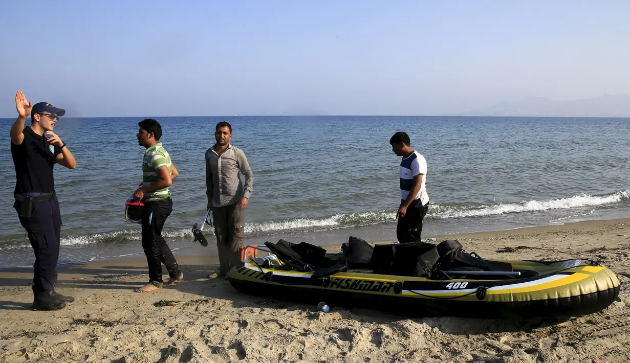 Petugas Pantai Yunani berbincang dengan para imigran Afghanistan yang tiba usai melintasi Laut Aegea antara Turki dan Yunani, (8/8/2015). PBB dan UNHCR memperkirakan bahwa Yunani telah menerima lebih dari 107.000 pengungsi. (REUTERS/Yannis Behrakis)