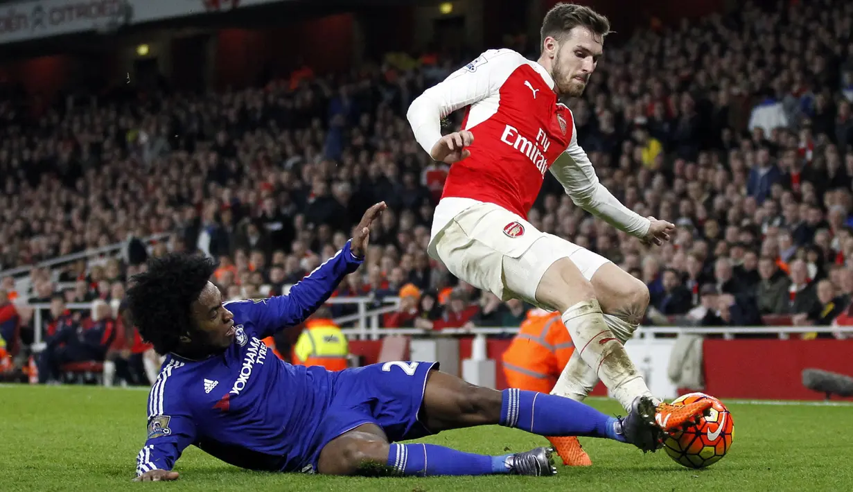 Pemain Chelsea, Willian (kiri) berebut bola dengan pemain Arsenal, Aaron Ramsey pada laga lanjutan Liga Inggris 2015/2016 di Emirates Stadium, London, 24 Januari 2016. Willian hengkang dari Stamford Bridge ke Arsenal pada 2020 lalu dengan status bebas transfer. (AFP/Ikimages)