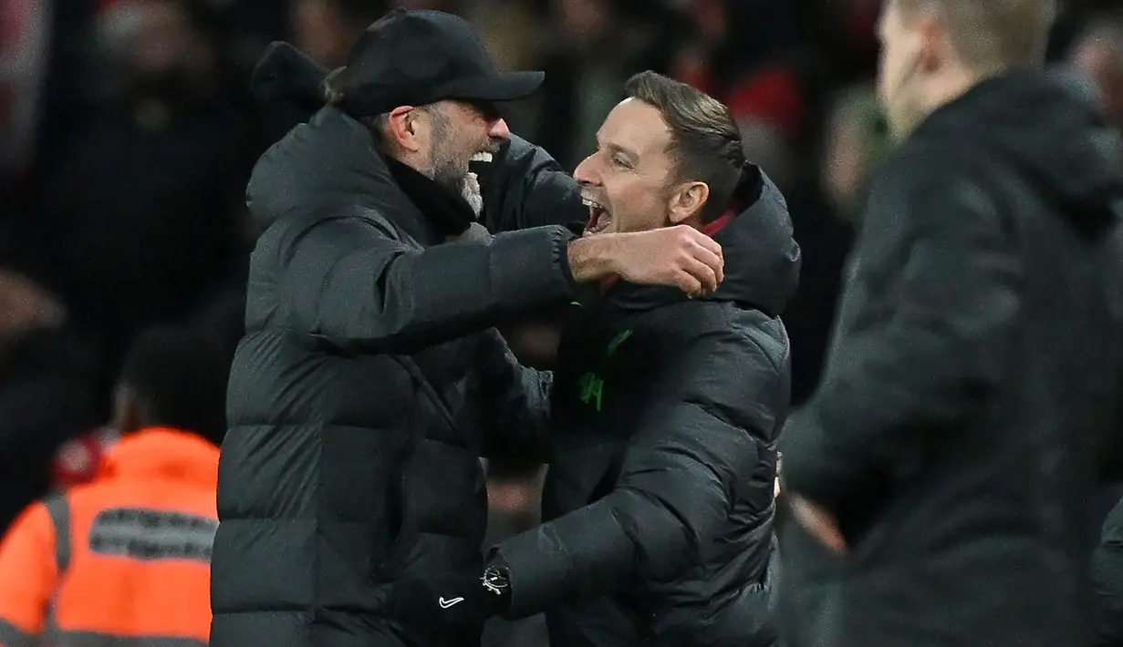 Ekspresi bahagia pelatih Liverpool, Jurgen Klopp (kiri), dengan memeluk asisten pelatih, Pepijn Lijnders (tengah), setelah Liverpool memenangkan pertandingan putaran ketiga FA Cup 2023/2024 melawan Arsenal yang berlangsung di Emirates Stadium, Minggu (7/1/2024) malam WIB. (AFP/Ben Stansall)
