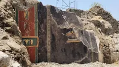 Foto selebaran yang diambil dan dirilis pada 25 Juni 2023 oleh Parco Archeologico di Pompei (Taman Arkeologi Pompeii) ini, menunjukkan sebuah lukisan Pompeii berusia 2.000 tahun yang ditemukan oleh penggalian Regio IX yang baru, digambarkan di dinding rumah Pompeii kuno yang mungkin merupakan nenek moyang pizza modern. (Handout / Parco Archeologico di Pompei press office / AFP)