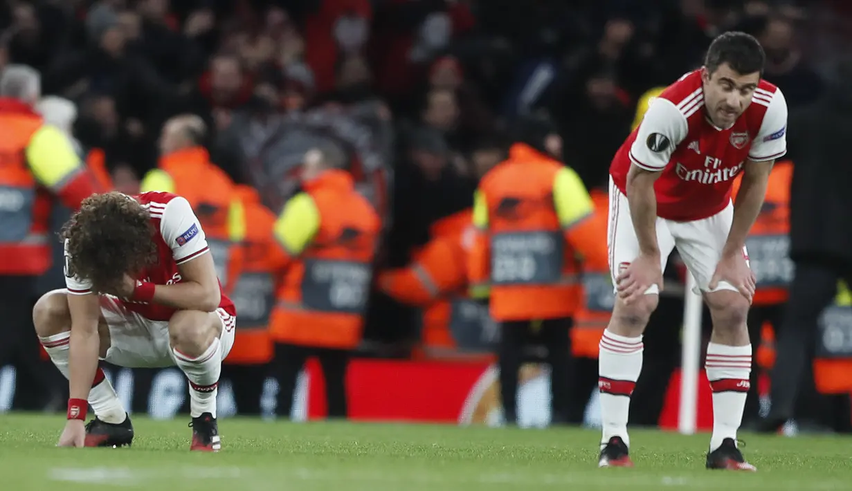 Pemain Arsenal tertenduk lesu usai pertandingan melawan Olympiakos pada leg kedua babak 32 besar Liga Europa di stadion Emirates, London, Kamis (27/2/2020).  Olympiakos menang 2-1 dan lolos dengan unggul agregat gol tandang 2-2. (AP Photo/Frank Augstein)