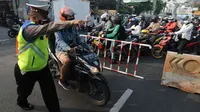 Petugas polisi memberhentikan pengendara motor saat memeriksa kelengkapan STR pada pos  perpanjangan Pemberlakuan Pembatasan Kegiatan Masyarakat (PPKM) Jalan Raya Ir.H.Djuanda, depan Sandratex, Tangerang Selatan, Kamis (15/07/2021). (merdeka.com/Arie Basuki )