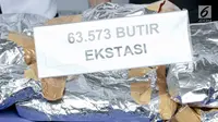 Barang bukti ekstasi diperlihatlan saat rilis penyelundupan narkoba jaringan Malaysia di Gedung BNN, Jakarta, Selasa (16/10). BNN berhasil menggagalkan penyelundupan 14,6 kg sabu dan 63.573 ekstasi dari 4 kasus berbeda. (Liputan6.com/Immanuel Antonius)