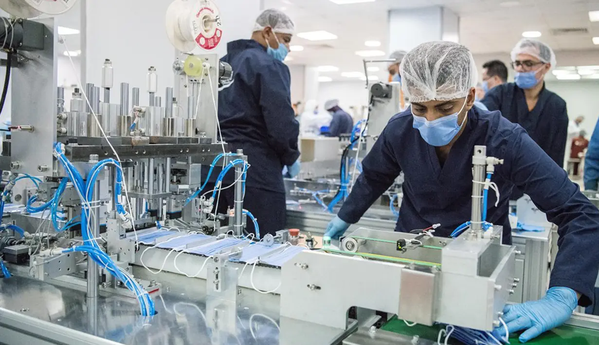 Orang-orang bekerja di sebuah pabrik yang memproduksi masker medis di Kairo, Mesir, 14 April 2020. Para karyawan bekerja siang dan malam untuk mengoperasikan lima mesin canggih yang dibawa dari China untuk memproduksi hingga 750.000 masker medis per hari. (Xinhua/Wu Huiwo)