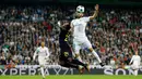 Pemain Real Madrid, Karim Benzema melompat untuk merebut bola dari pemain Tottenham Hotspur Serge Aurier pada laga lanjutan fase Grup H Liga Champions di Santiago Bernabeu, Selasa (17/10). Madrid ditahan imbang tamunya Tottenham 1-1.  (AP/Francisco Seco)