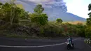 Warga mengendarai motor saat Gunung Agung Mengeluarkan abu vulkanik di Kecamatan Kubu, Karangasem, Bali, Minggu (26/11). Semburan asap dan abu vulkanik Gunung Agung mencapai ketinggian 1.500 meter dari puncak Gunung Agung. (AFP/Sonny Tumbelaka)