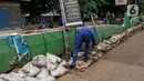 Petugas Dinas Sumber Daya Air melakukan perbaikan turap Kali Baru, Jakarta, Selasa (16/11/2021). Perbaikan turap sebagai antisipasi meluapnya aliran air yang menyebabkan banjir di kawasan tersebut. (Liputan6.com/Johan Tallo)