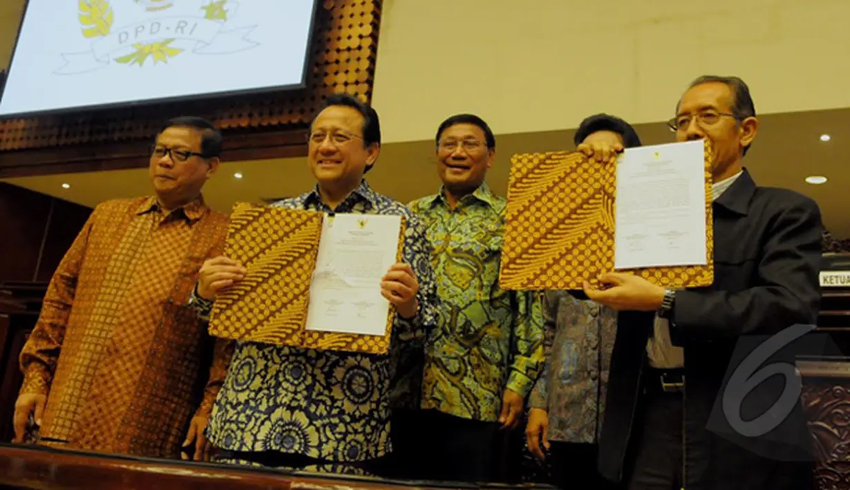 Ketua Dewan Perwakilan Daerah (DPD) RI Irman Gusman (kedua kiri) memperlihatkan laporan LHKPN yang sudah ditanda tangani bersama Wakil Ketua KPK Zulkarnain (kanan) saat Sidang Paripurna  DPD, Jakarta, Rabu (18/02/2015).  (Liputan6.com/Andrian M Tunay)
