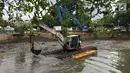 Alat berat digunakan untuk mengeruk lumpur dan sampah yang mengendap di anak Sungai Ciliwung, Jakarta, Jumat (26/1). Pengerukan dilakukan untuk mencegah pendangkalan sungai. (Liputan6.com/Immanuel Antonius)