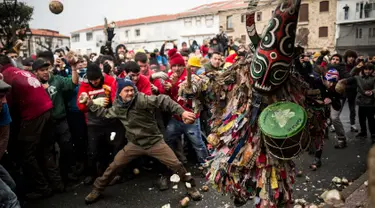 Orang-orang melempari seorang pria berkostum ala setan dengan sayuran lobak selama Festival Jarramplas di kota Piornal, Spanyol, Sabtu (19/1). Sosok "setan" itu disebut dengan Jarramplas yang dikenakan salah satu pemuda desa terpilih. (AP/Javier Fergo)