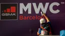 Pekerja memperbaiki poster yang mengumumkan Mobile World Congress (MWC) 2020 di lokasi pameran di Barcelona, Spanyol, Selasa (11/2/2020). Total kerugian akibat dibatalkannya MWC 2020 diperkirakan mencapai Rp 7,3 triliun). (AP Photo/Emilio Morenatti)