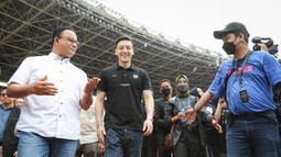 Mesut Ozil (tengah) didampingi Gubernur DKI Jakarta, Anies Baswedan saat menghadiri acara coaching clinic yang digelar oleh Concave Indonesia bersama 47 anak Indonesia terpilih di Stadion Utama Gelora Bung Karno (SUGBK) Senayan, Jakarta, Kamis (26/5/2022) sore WIB. (Bola.com/Bagaskara Lazuardi)
