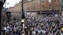 Fans berkumpul untuk menyaksikan parade kemenangan Manchester City dalam Liga Inggris di Manchester, Inggris, 23 Mei 2022. (AP Photo/Jon Super)