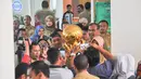 Para pegawai Pemerintah Kota Batu berebut foto dengan trophy Piala Bhayangkara 2016 di Malang, Jawa Timur, Selasa (11/4/2016). Kunjungan Arema Cronus ke Pemkot Batu menghasilkan bonus 100 juta rupiah. (Bola.com/Iwan Setiawan)