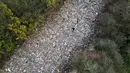 Badan Lingkungan Hidup (Environment Agency) setempat sedang menyelidiki insiden tersebut dan telah mendesak saksi untuk melapor. Tampak foto udara memperlihatkan aktivis lingkungan sedang merekam konten untuk media sosial di tumpukan sampah ilegal yang besar, yang dibuang di sebuah ladang antara Sungai Cherwell dan Jalan A34 dekat Kidlington, Oxfordshire, di barat London pada 16 November 2025. (Justin TALLIS/AFP)