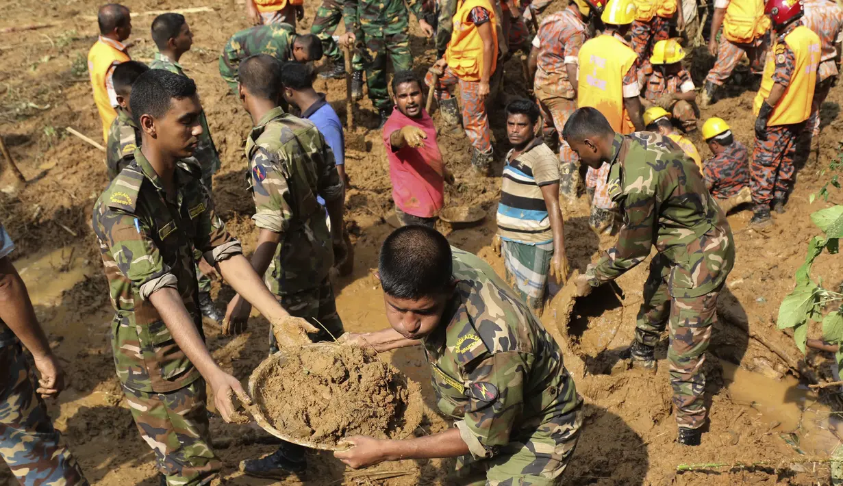 Petugas dan warga mencari warga yang tertimbun longsor di Rangamati, Bangladesh, Rabu (14/6). Sedikit-dikitnya 134 orang tewas akibat bencana tanah longsor tersebut. (AP Photo)