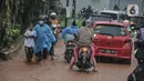 Kendaraan bergerak perlahan melintasi genangan lumpur di Jalan Raya Sawangan, Depok, Minggu (7/11/2021). Menurut warga setempat, banjir bercampur lumpur tersebut merupakan yang pertama kali yang diduga disebakan oleh proyek waduk perumahan yang belum rampung. (merdeka.com/Iqbal S Nugroho)