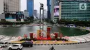 Sejumlah pengendara kendaran bermotor melintasi dekorasi ornamen khas perayaan Imlek di Bundaran Hotel Indonesia, Jakarta, Senin (27/1/2025). (Liputan6.com/Angga Yuniar)