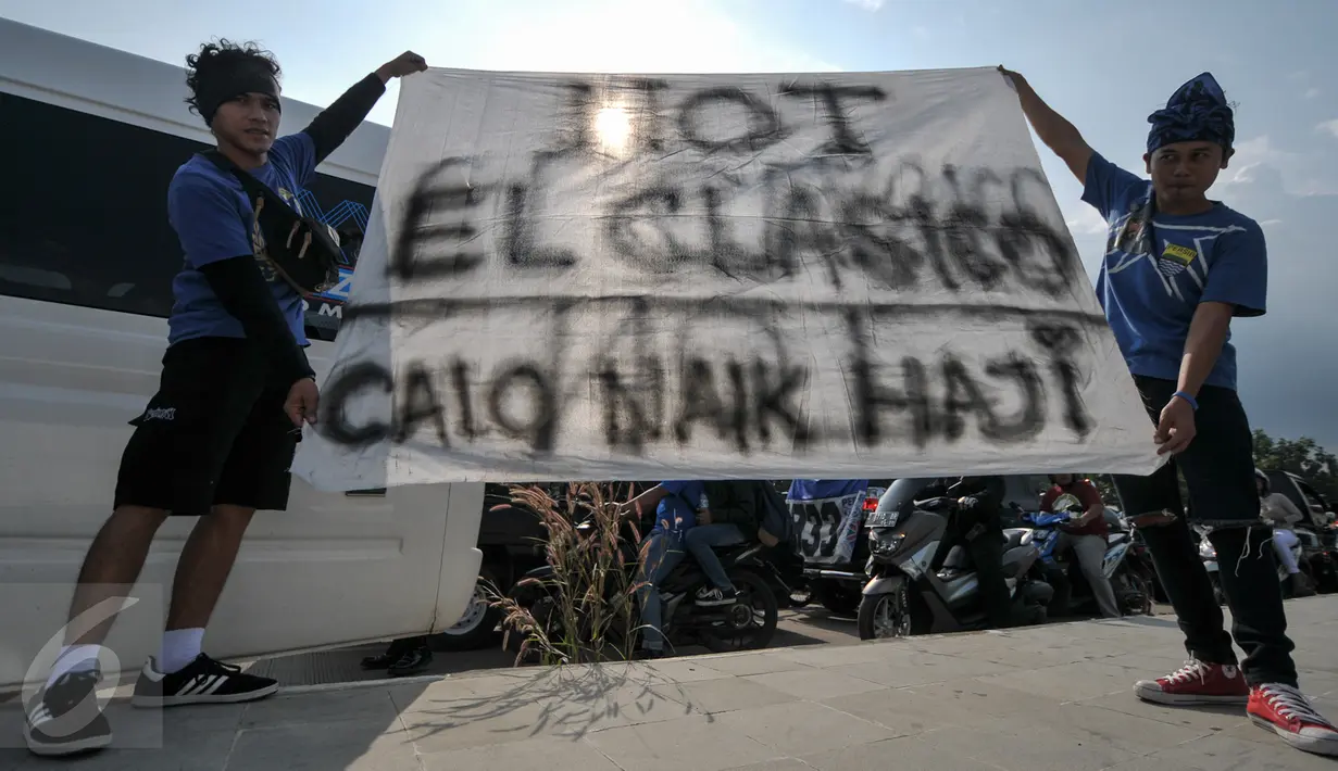 Dua orang pendukung Persib Bandung, Bobotoh, membawa spanduk di Stadion Gelora Bandung Lautan Api, Sabtu (16/7). Mereka akan menyaksikan tim kesayangannya menjamu Persija Jakarta dalam pekan 10 Torabika Soccer Championship (Liputan6.com/Yoppy Renato)