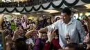 Peniru Presiden Filipina Rodrigo Duterte, Cresencio Extreme bersamalan dengan jemaat gereja di pusat Hong Kong, 3 Februari 2019. Suasana misa mendadak riuh setelah kedatangan dua sosok yang mirip dengan Duterte dan Kim Jong Un. (ISAAC LAWRENCE/AFP)