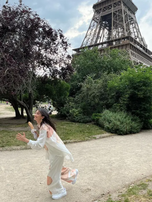 Kemeja asimetris dengan motif bunga yang dikenakannya beri kesan santai dan nyaman. [@ralineshah]